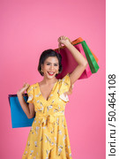 Beautiful asian woman holding colored shopping bags. Стоковое фото, агентство Ingram Publishing / Фотобанк Лори