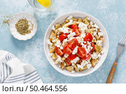 Dakos or koukouvagia salad. Classic recipe Cretan barley rusk salad with fresh tomato, mizithra cheese and oregano. Traditional mediterranean Greek cuisine. Healthy food, diet. Top view. Стоковое фото, агентство Ingram Publishing / Фотобанк Лори