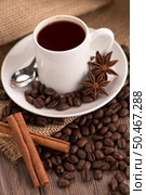 Coffee cup with burlap sack of roasted beans on rustic table. Стоковое фото, агентство Ingram Publishing / Фотобанк Лори