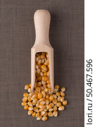Top view of wooden scoop with corn against brown vinyl background. Стоковое фото, агентство Ingram Publishing / Фотобанк Лори
