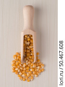 Top view of wooden scoop with corn against beige vinyl background. Стоковое фото, агентство Ingram Publishing / Фотобанк Лори