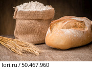 Rustic bread and wheat on an old vintage planked wood table. Стоковое фото, агентство Ingram Publishing / Фотобанк Лори