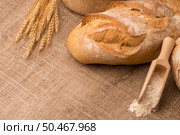 Rustic bread and wheat on an old vintage planked wood table. Стоковое фото, агентство Ingram Publishing / Фотобанк Лори
