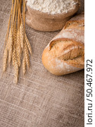 Rustic bread and wheat on an old vintage planked wood table. Стоковое фото, агентство Ingram Publishing / Фотобанк Лори