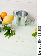 Limes inside metal bucket on the light green wooden table. Стоковое фото, агентство Ingram Publishing / Фотобанк Лори