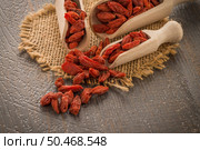 Goji berries on a wooden spoons, wooden background. Стоковое фото, агентство Ingram Publishing / Фотобанк Лори