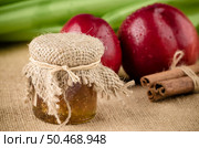 Peach jam with fruit and cinnamon over raffia background. Стоковое фото, агентство Ingram Publishing / Фотобанк Лори