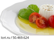 Fresh salad with goat cheese, tomato and basil pesto on a white plate. Стоковое фото, агентство Ingram Publishing / Фотобанк Лори