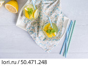 Summer citrus fruits drink on wooden background. Detox citrus infused flavored water. Refreshing summer homemade cocktail with lemon. Fresh lemon and lemonade on wooden background. Стоковое фото, агентство Ingram Publishing / Фотобанк Лори