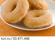 Closeup of donuts on a plate on orange straw mat background. Стоковое фото, агентство Ingram Publishing / Фотобанк Лори