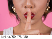 Beauty asian woman red lips and finger showing hush silence sign. Стоковое фото, агентство Ingram Publishing / Фотобанк Лори