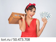 Retro fashion women hand take a luggage and dollar money to travel. Стоковое фото, агентство Ingram Publishing / Фотобанк Лори