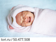 Newborn baby wrapped in a soft pink blanket and crying. Стоковое фото, агентство Ingram Publishing / Фотобанк Лори