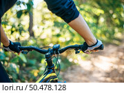 Mountain cyclists grasp the bike handle, focus on gloves. Стоковое фото, агентство Ingram Publishing / Фотобанк Лори