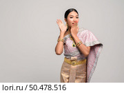 women is wearing Thai clothes and hand-made to cover her mouth. Стоковое фото, агентство Ingram Publishing / Фотобанк Лори