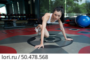 Young women warms up before exercising by pushing the floor and bending his knees in Gym. Стоковое фото, агентство Ingram Publishing / Фотобанк Лори