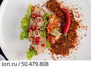 Spicy pork salad with galangal, lemon, chilli, garlic and put in a salad on a white plate. Стоковое фото, агентство Ingram Publishing / Фотобанк Лори