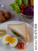 American breakfast on a white background with boiled eggs, corn, tomato and sandwich on a white plate. Стоковое фото, агентство Ingram Publishing / Фотобанк Лори