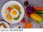 American breakfast on a white background with fried egg, salad, pumpkin, cucumber, carrot, corn, cauliflower, tomato, toast and orange juice. Стоковое фото, агентство Ingram Publishing / Фотобанк Лори
