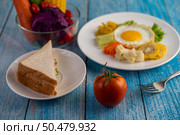 American breakfast on a white background with fried egg, salad, pumpkin, cucumber, carrot, corn, cauliflower, tomato and sandwich . Стоковое фото, агентство Ingram Publishing / Фотобанк Лори