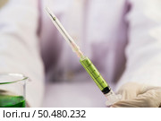 Scientists wearing masks and gloves Holding a syringe with a vaccine to prevent covid-19. Стоковое фото, агентство Ingram Publishing / Фотобанк Лори