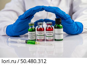 Scientists wear blue gloves and make hands unacceptable vaccine  Selective focus. Стоковое фото, агентство Ingram Publishing / Фотобанк Лори