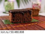 Chocolate cake on a banana leaf on a bamboo plate. Selective focus. Стоковое фото, агентство Ingram Publishing / Фотобанк Лори