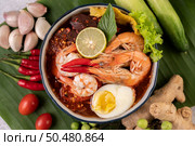 Tom Yum noodle with shrimp and boiled egg, accompanied by lime, cucumber, basil, eggplant and garlic. Стоковое фото, агентство Ingram Publishing / Фотобанк Лори