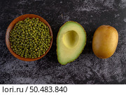 Mung bean, avocado, and kiwi on a black cement floor background. Стоковое фото, агентство Ingram Publishing / Фотобанк Лори