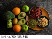 legumes and fruit on a black cement floor background. Стоковое фото, агентство Ingram Publishing / Фотобанк Лори