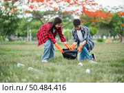 Men and women helped to collect garbage in a black bag. Стоковое фото, агентство Ingram Publishing / Фотобанк Лори
