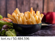 French fries in a black cup on the cement ground. Selective focus. Стоковое фото, агентство Ingram Publishing / Фотобанк Лори