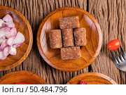 Palm sugar and red onions on a wooden plate with a tomato skewer on the wooden floor. Стоковое фото, агентство Ingram Publishing / Фотобанк Лори