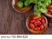Palm sugar, red onions, dried peppers, tomatoes, cucumbers, yard long beans and lettuce in a bowl. Стоковое фото, агентство Ingram Publishing / Фотобанк Лори