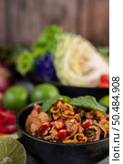 Spicy pork chops in a black cup consisting of lemons Chili and side dishes. Selective focus. Стоковое фото, агентство Ingram Publishing / Фотобанк Лори