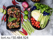 Spicy pork chops on a black plate consisting of lemons Chili and side dishes. Selective focus. Стоковое фото, агентство Ingram Publishing / Фотобанк Лори
