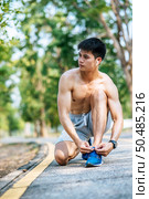 That man laced a shoelace to exercise. Selective focus. Стоковое фото, агентство Ingram Publishing / Фотобанк Лори