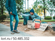 Beggars wrapped in cloth and then put on a hat and sat down beside the street and someone gave money. Стоковое фото, агентство Ingram Publishing / Фотобанк Лори