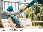 The man sitting begging on an overpass with messages homeless people please help and work well with food. Стоковое фото, агентство Ingram Publishing / Фотобанк Лори