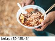 The beggar stands to hold with noodles in a foam cup complete with chopsticks and spoons. Стоковое фото, агентство Ingram Publishing / Фотобанк Лори
