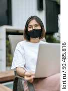 Women wearing masks and playing laptops at the poolside. Selective focus. Стоковое фото, агентство Ingram Publishing / Фотобанк Лори