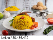 Chicken Biryani in a plate with spices on a white wooden floor. Стоковое фото, агентство Ingram Publishing / Фотобанк Лори