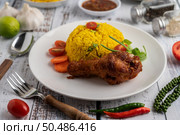 Chicken Biryani in a plate with spices on a white wooden floor. Стоковое фото, агентство Ingram Publishing / Фотобанк Лори