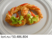 Freshly baked soft pretzel with generous sprinkling of coarse salt and sesame on white dish, decorate with lettuce and carrot beautifully, copy space. Стоковое фото, агентство Ingram Publishing / Фотобанк Лори