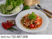 Thai papaya salad in a white plate with chili, lime, and garlic. Top view. Стоковое фото, агентство Ingram Publishing / Фотобанк Лори
