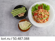 Thai papaya salad in a white plate with Yardlong beans, garlic, and Collard white. Top view. Стоковое фото, агентство Ingram Publishing / Фотобанк Лори