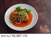 Horizontal image the Spicy salad of sardine with tomato sauce in white dish on wooden table, mixed with herb and lemonade, copy space. Стоковое фото, агентство Ingram Publishing / Фотобанк Лори