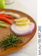 Vertical image, Selective focus the shredded kaffir lime leaves and blurred herb for cooking ingredient on wooden tray, copy space. Стоковое фото, агентство Ingram Publishing / Фотобанк Лори