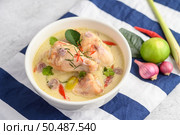 Tom Kha Kai in a bowl with kaffir lime leaves, lemongrass, red onion, galangal and chilli.Selective focus. Стоковое фото, агентство Ingram Publishing / Фотобанк Лори