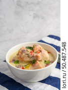 Tom Kha Kai in a bowl with kaffir lime leaves, lemongrass, red onion, galangal and chilli.Selective focus. Стоковое фото, агентство Ingram Publishing / Фотобанк Лори